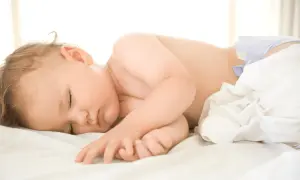 Sover sött i sin blöja, en trygg bebis som följer sina rutiner.