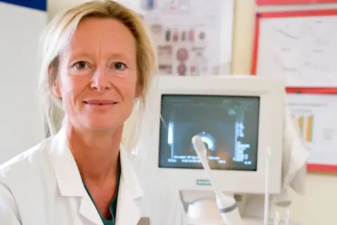 Läkare med ultraljudsapparat, redo för undersökning av hepatos gravid.