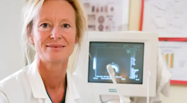 Läkare med ultraljudsapparat, redo för undersökning av hepatos gravid.