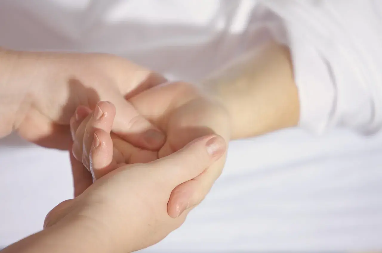 En hand masserar en annan handled, kanske för att lindra klåda gravid.