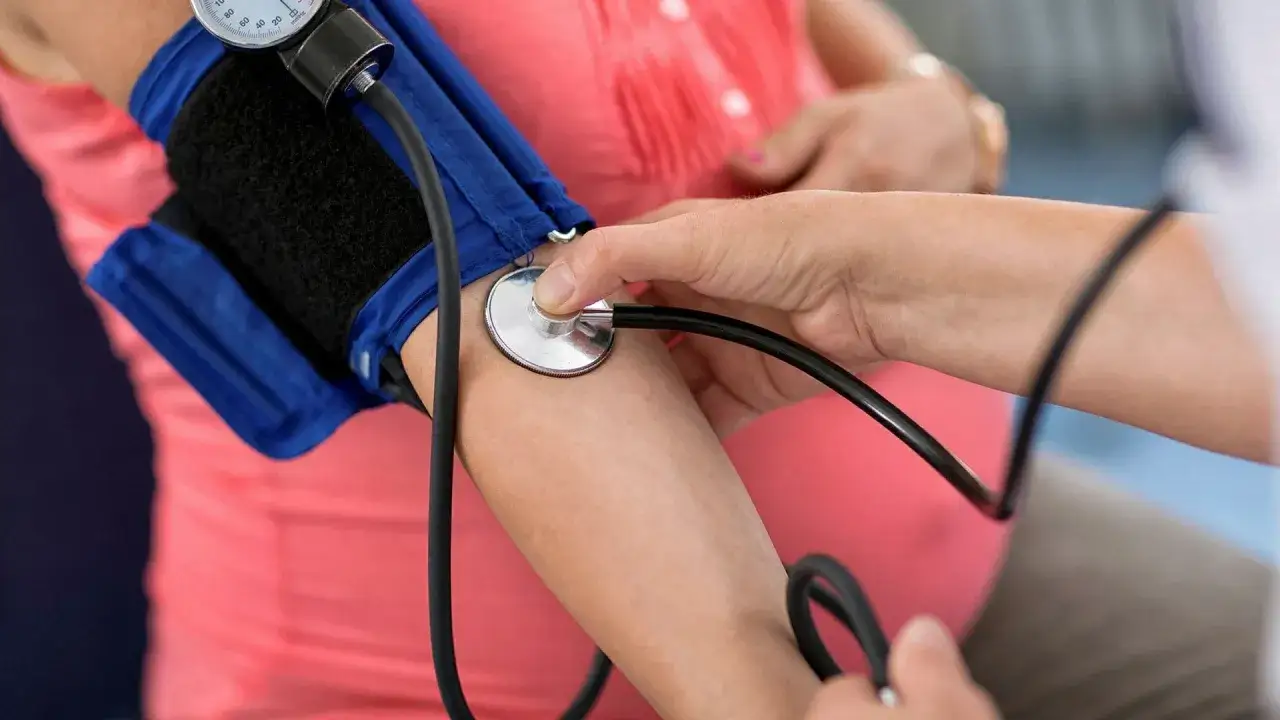 Gravid kvinna får blodtrycket mätt. Läkaren lyssnar med stetoskop. Synbortfall kan vara ett tecken på högt blodtryck.