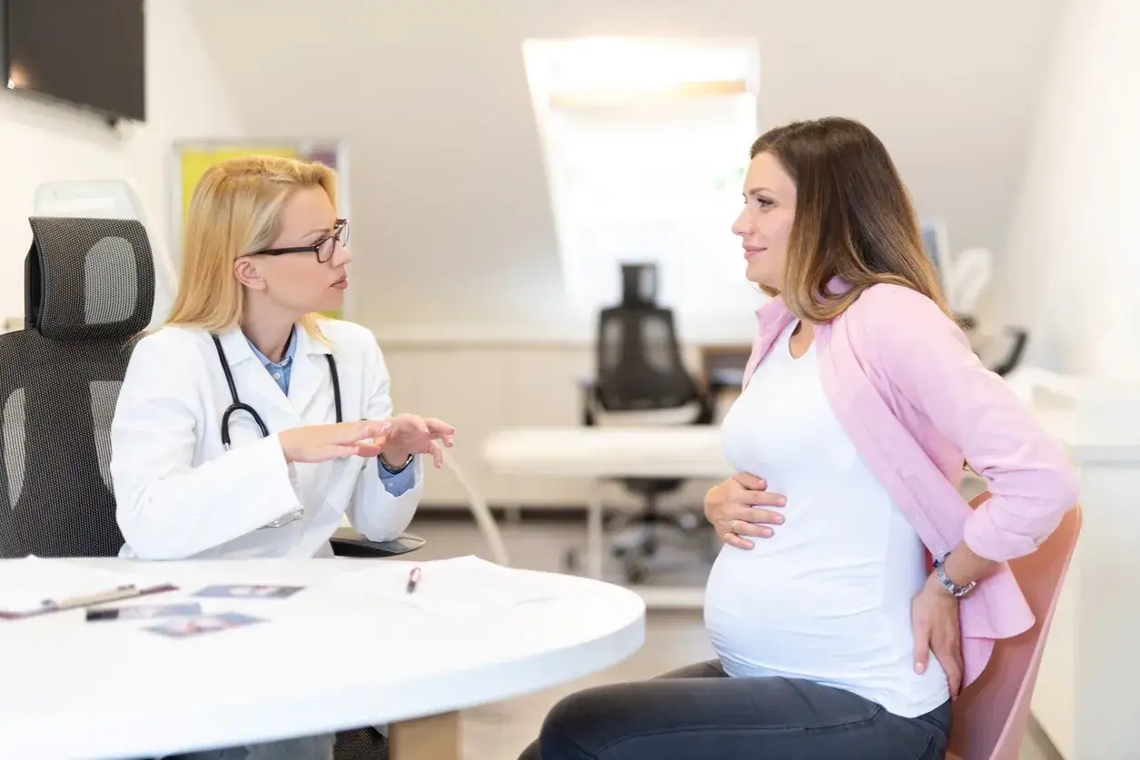 Läkare diskuterar med gravid kvinna om ilningar i underlivet.