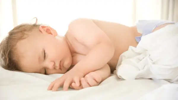 Sover sött i sin blöja, en trygg bebis som följer sina rutiner.